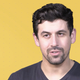 Ari Notis, in front of a Kotaku yellow background.